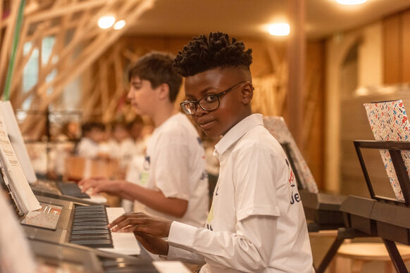 Zwei Jungen sitzen nebeneinander und spielen am Keyboard