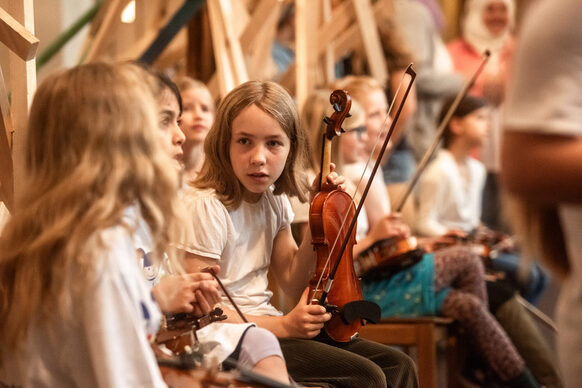 Kinder mit Musikinstrumenten unterhalten sich