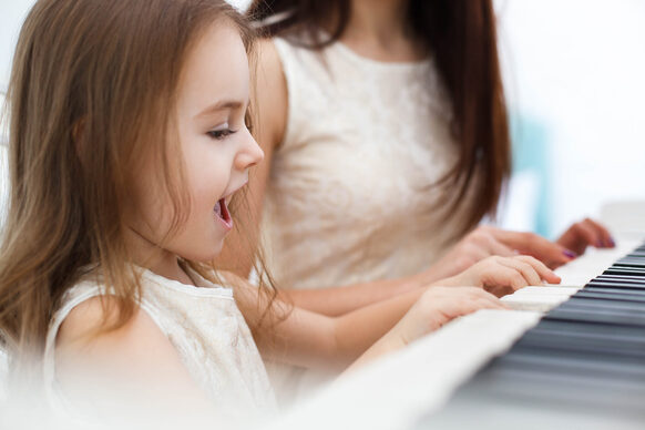 Little girl sings while she and another woman play piano