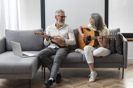 Älteres Ehepaar spielt Gitarre